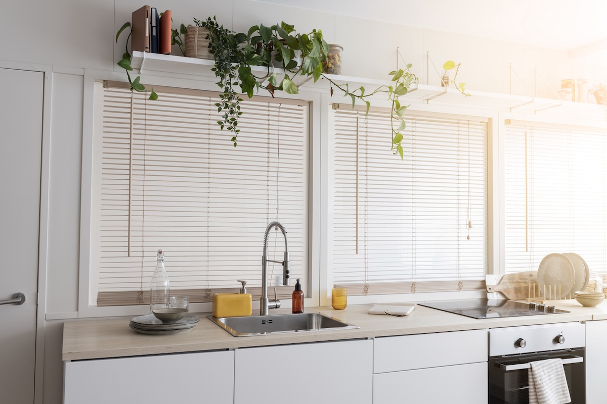 A bank of windows with blinds in a kitchen.