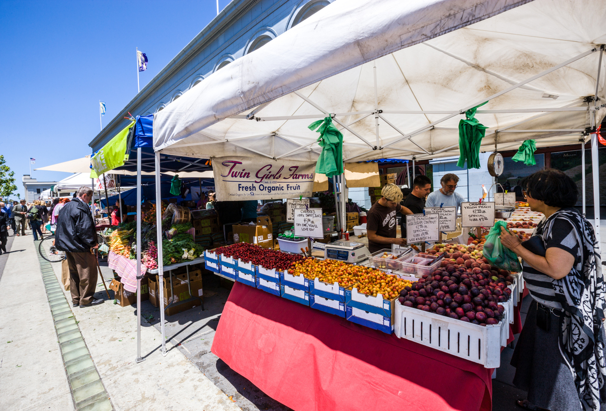 Farmer's Market in Port of San Francisco, people buying fresh organic fruits.