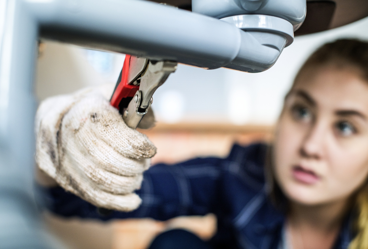 Woman fixing kitchen sink