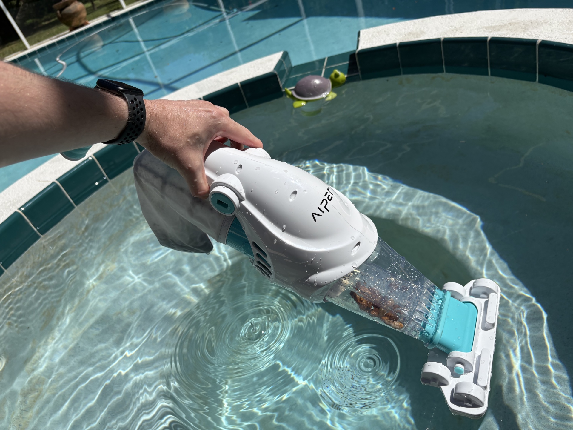 a person using Aiper Handheld Pool Vacuum