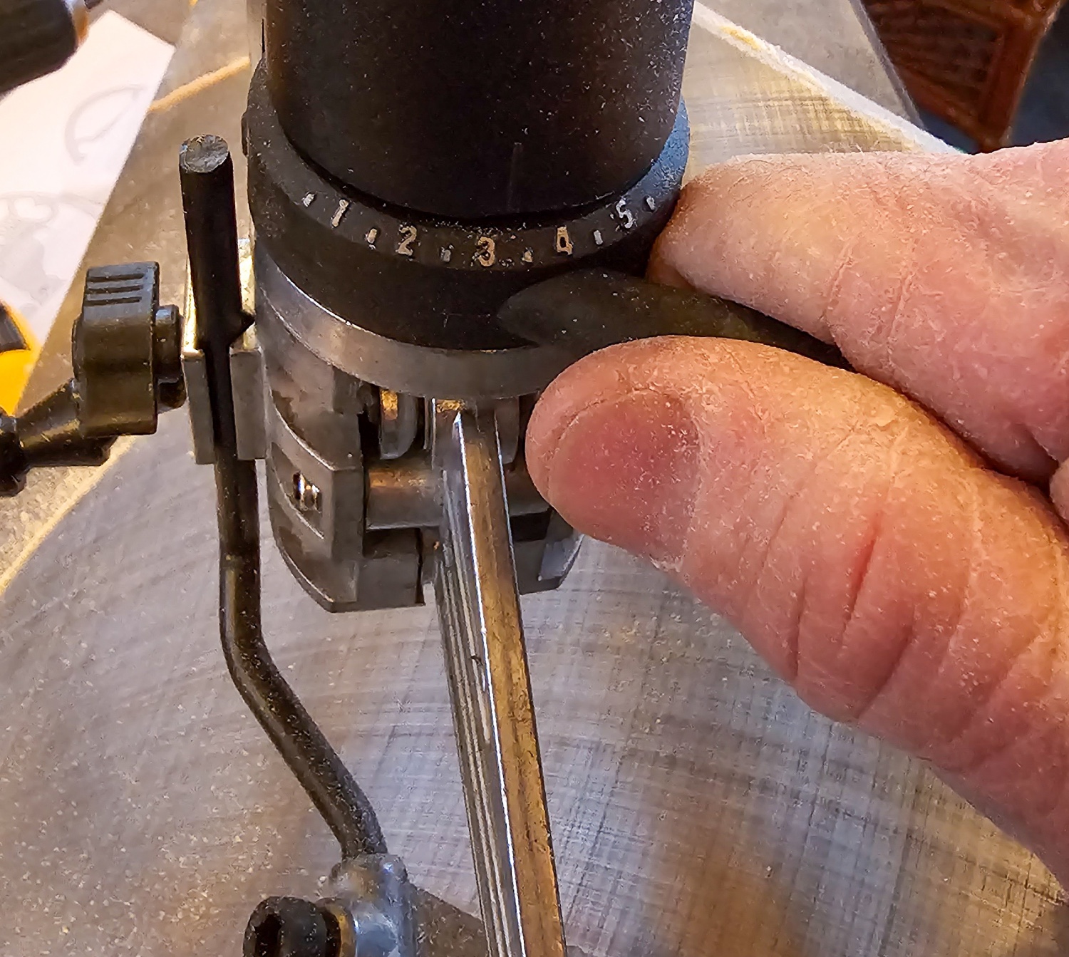 A person using the control knob on the DeWalt scroll saw to adjust the saw's speed.