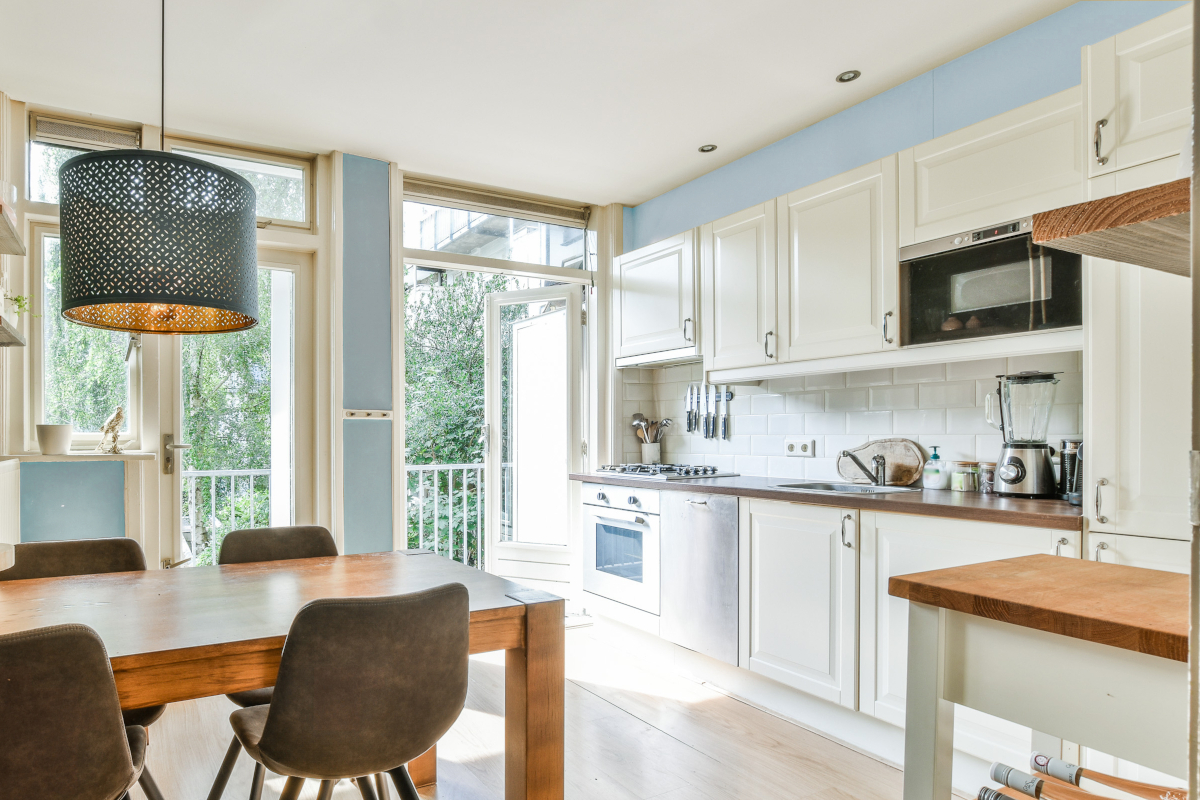 A small kitchen with a bluish-gray accent wall color.