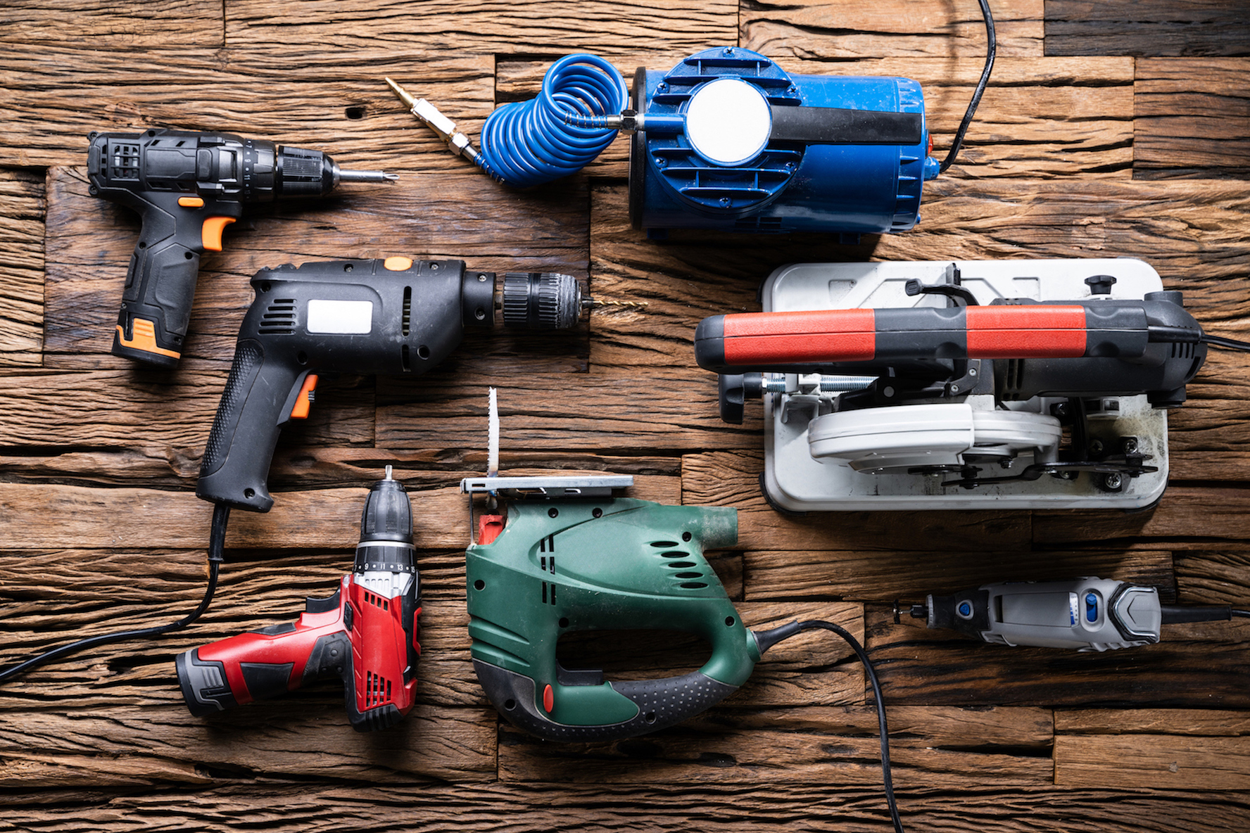 Various Power Tools Laying On Wooden Desk