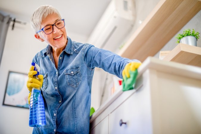 Older woman wiping counter.