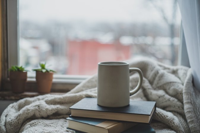 Mug on books and blanket.