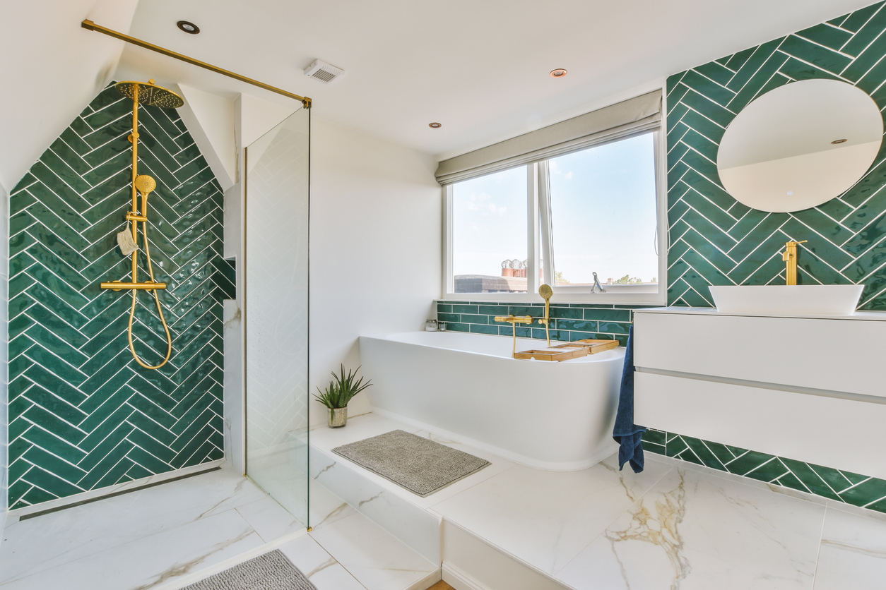 The interior of a bathroom decorated with marble and gold-colored equipment in a modern house