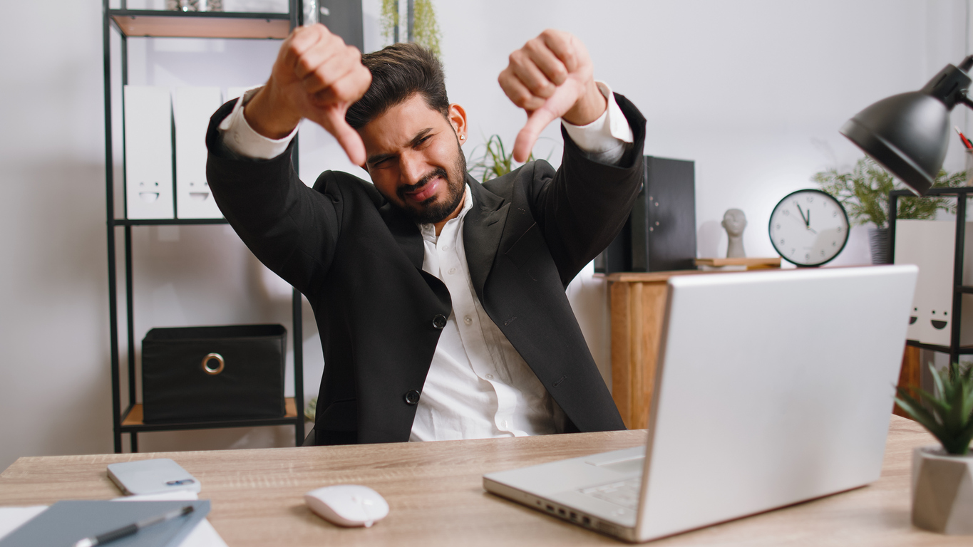 Upset businessman showing thumbs down, dislike bad work, disapproval dissatisfied feedback at office