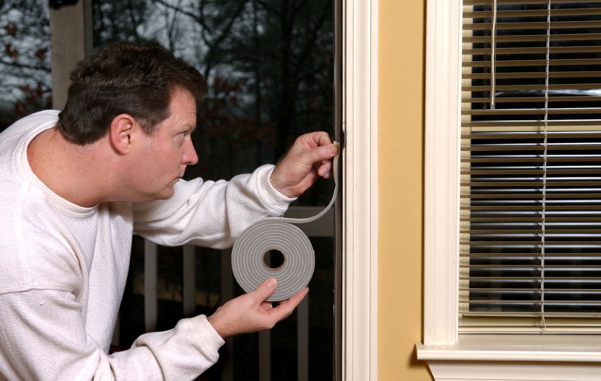 Man weather stripping door.