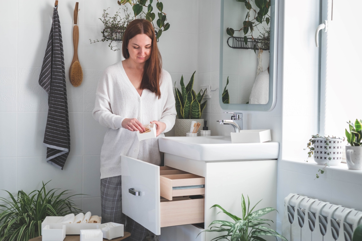 Woman organizing bathroom storage.