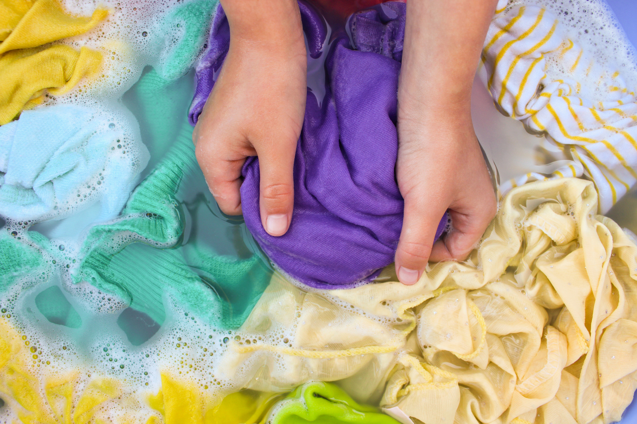 Multicolored laundry soaking in soapy water.