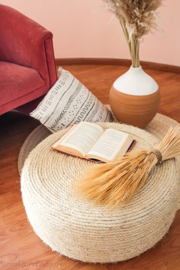 A cozy living room armchair with a round ottoman made from jumbo yarn.