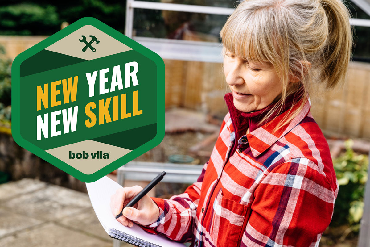 A woman in her backyard making notes about her diy landscape design.