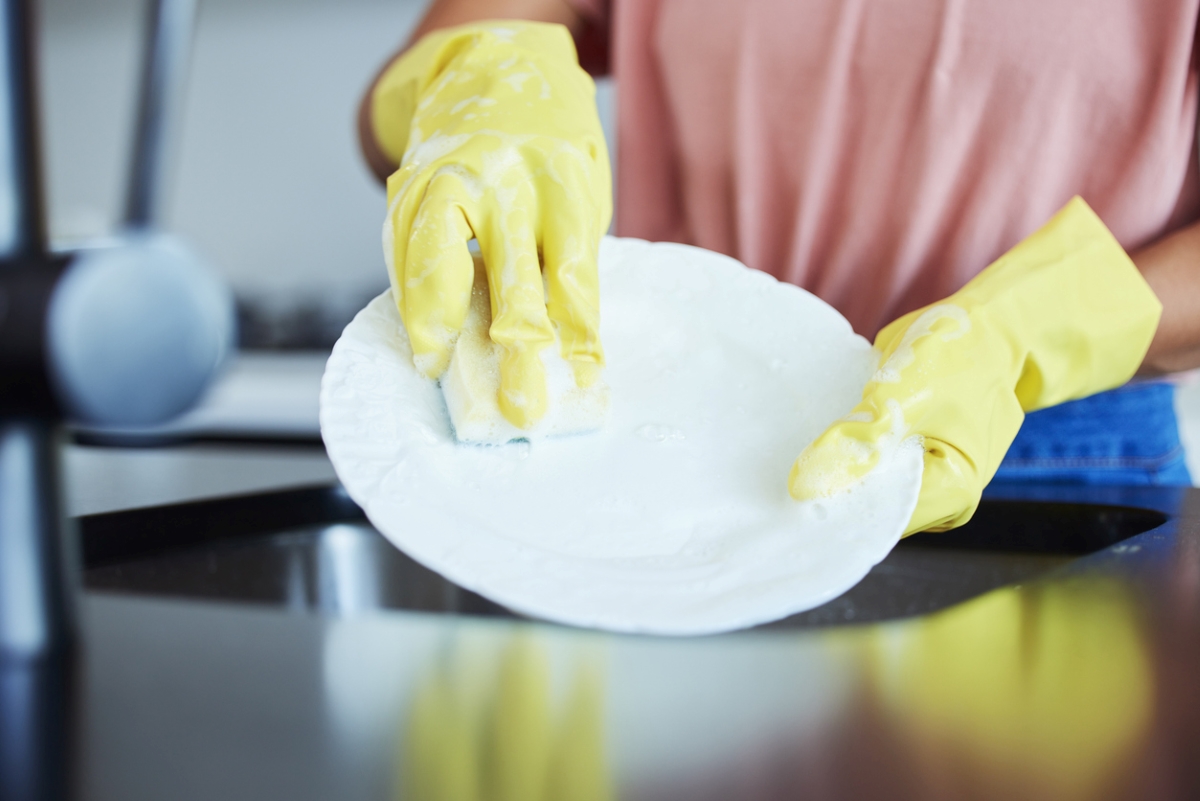 Person using sponge on dish.