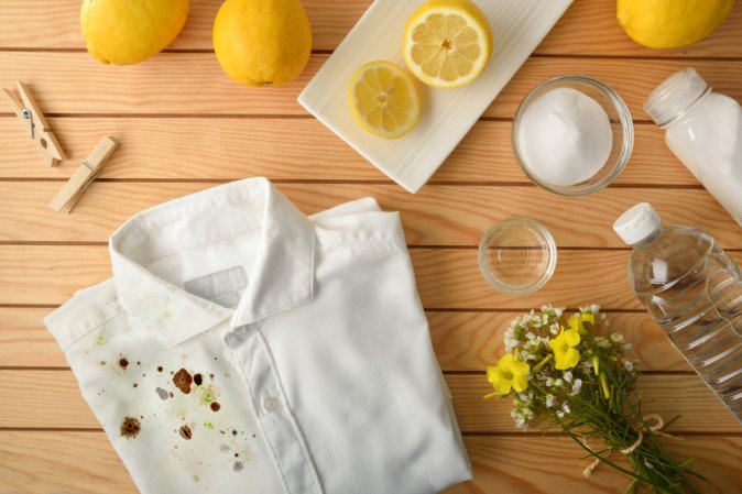 Stained shirt next to vinegar and other cleaning supplies.