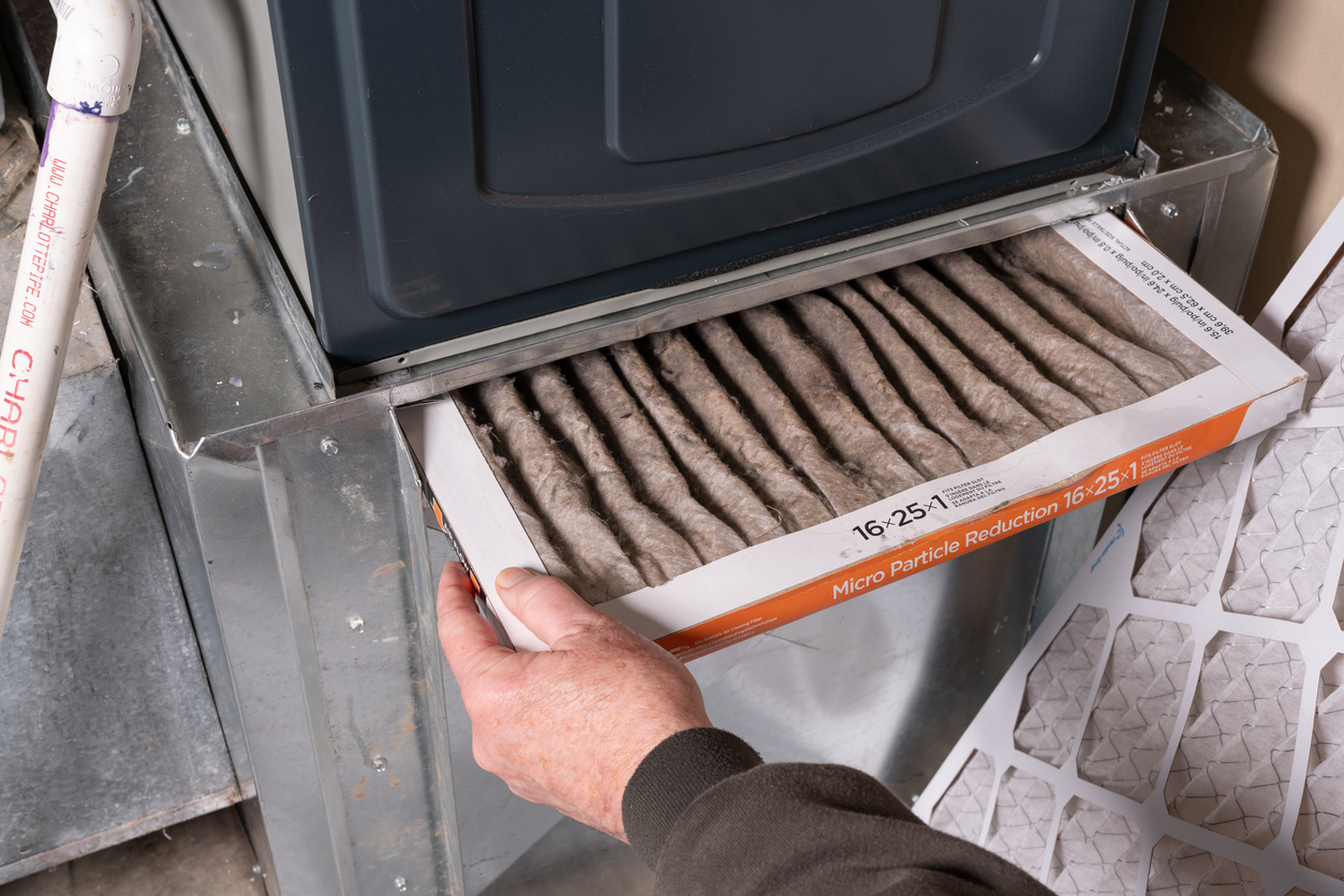 Man replacing dirty furnace filter in home