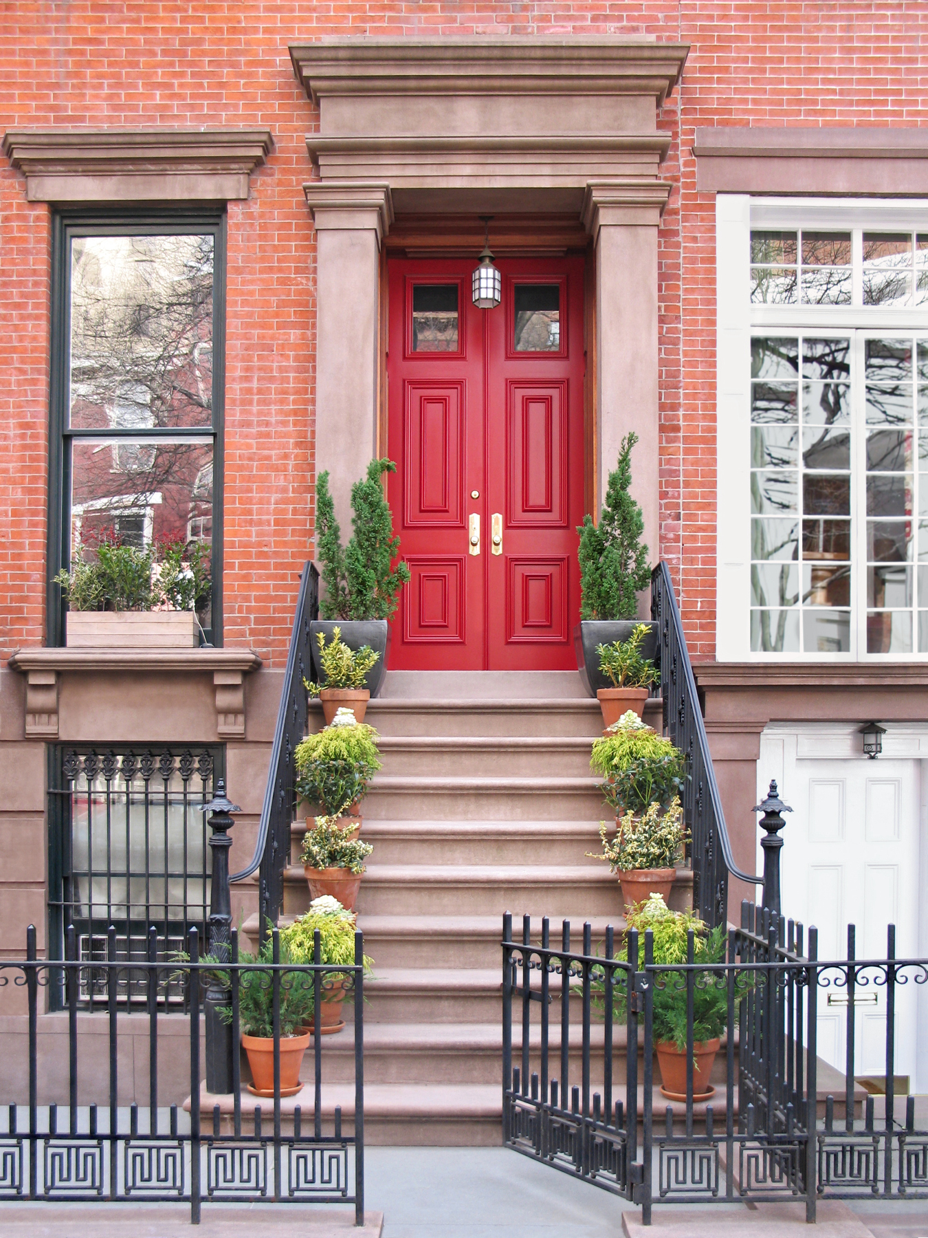 Townhouse entrance with ornate railings and gate.