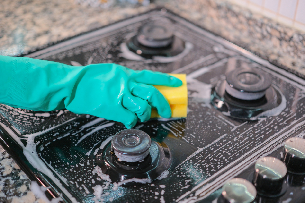 Woman is cleaning oven.