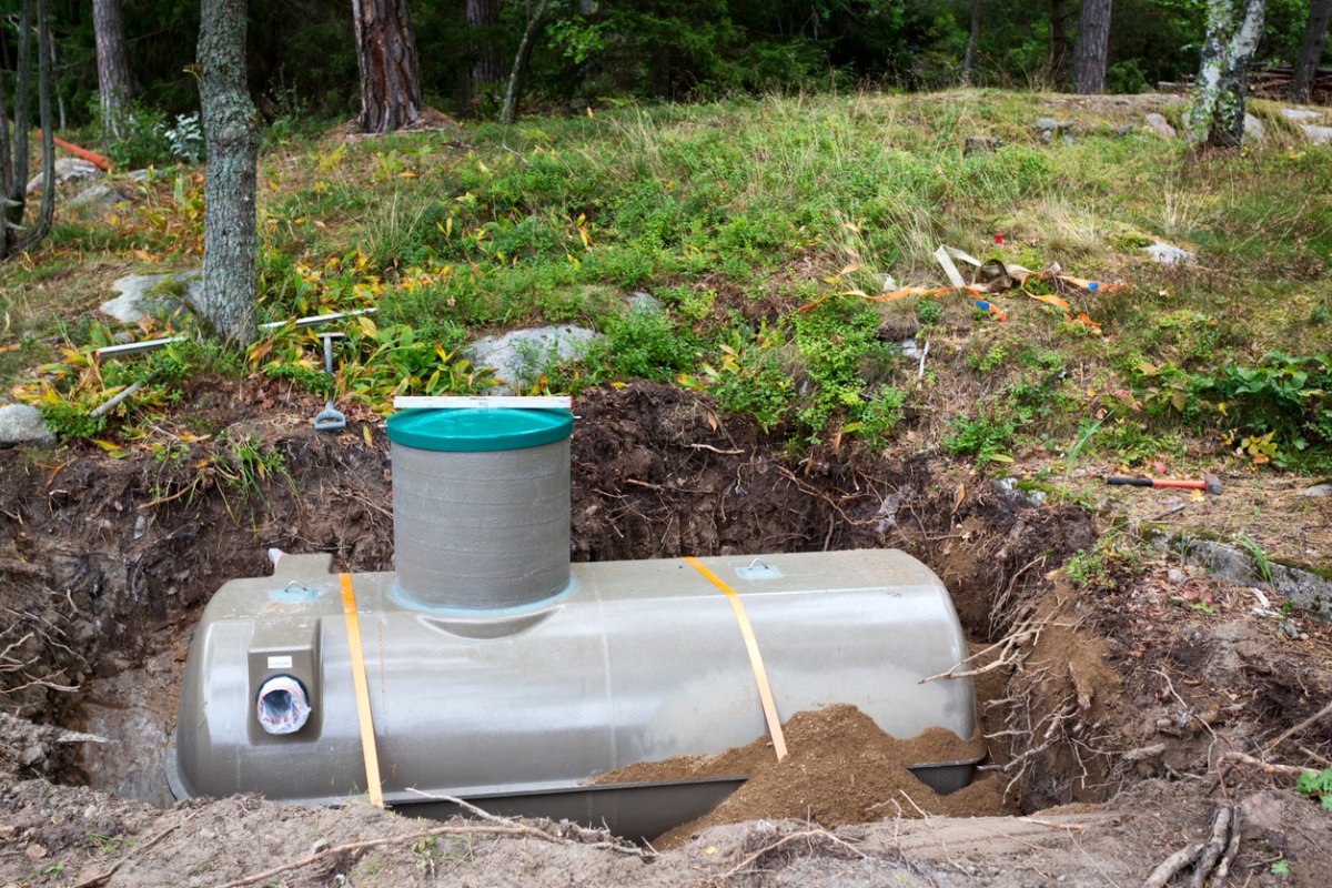 An exposed septic tank in a yard. 