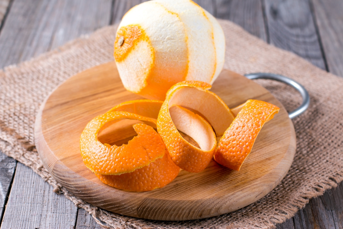 Peeled orange on wooden plate.