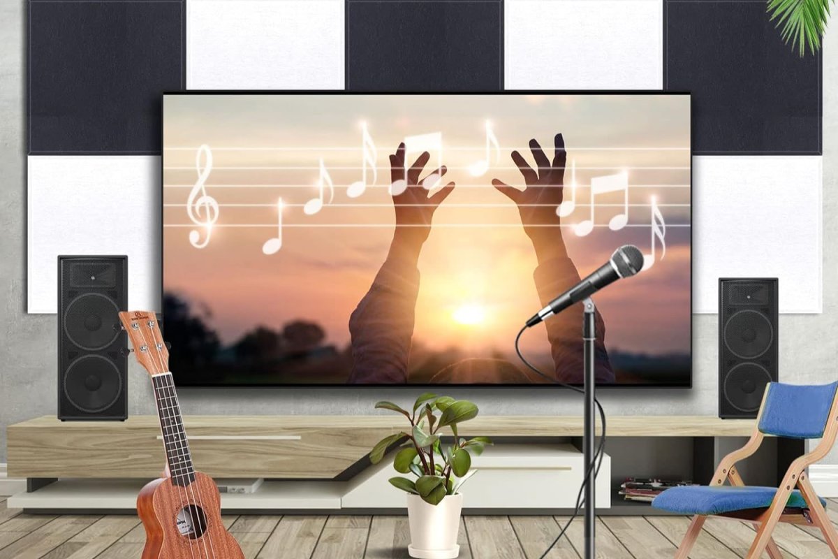 A section of wall covered in black and white soundproofing panels with a tv, guitar, and microphone set up in front of them.