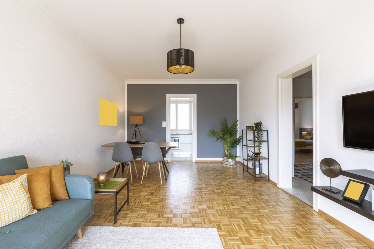 Narrow living room with far wall painted in dark grey.