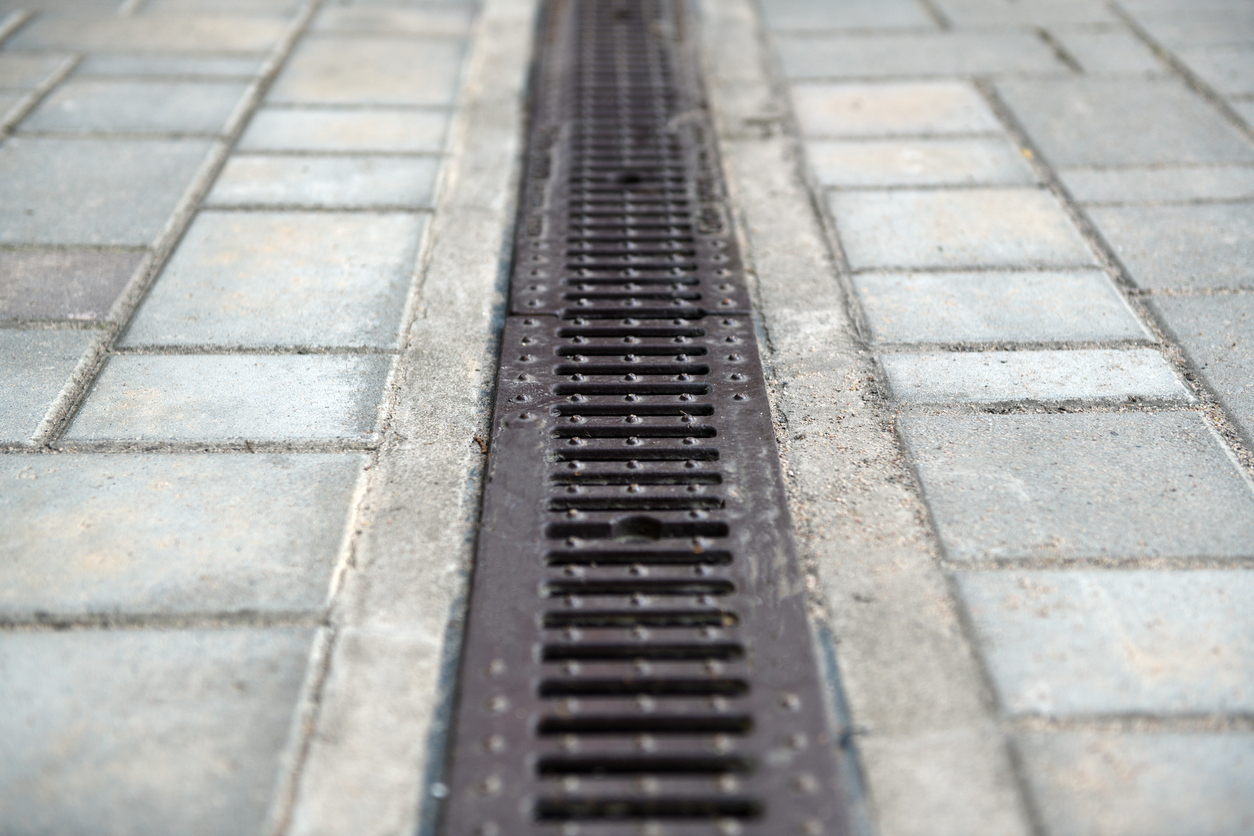 Channel drain in brick driveway.