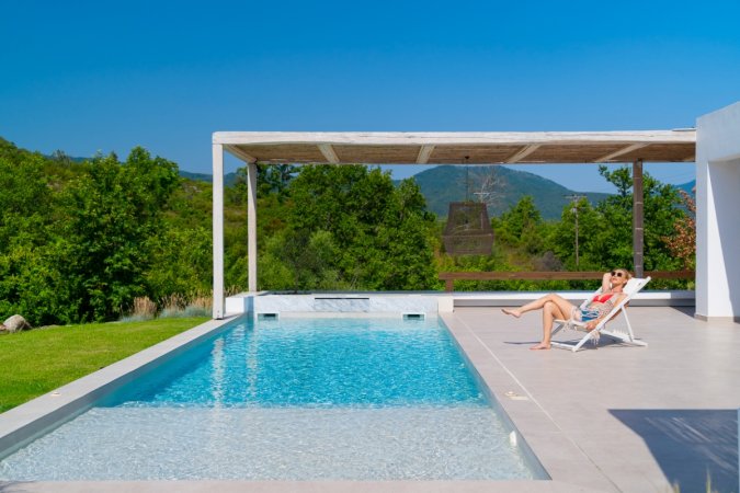 Woman sitting next to swimming pool.