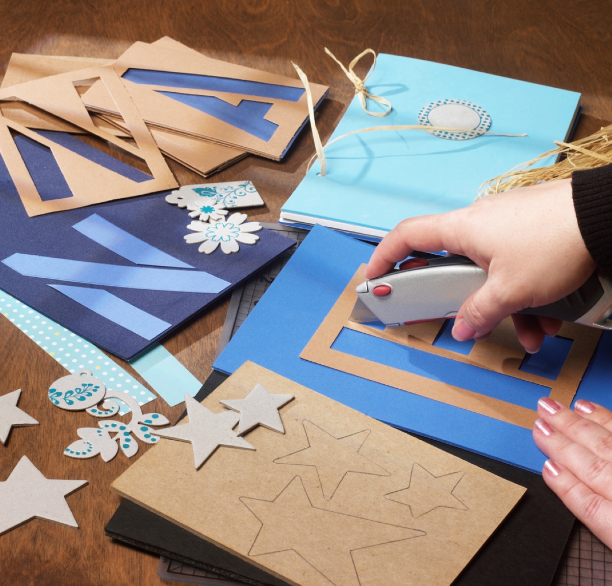 Hand using box cutter to make stencils.