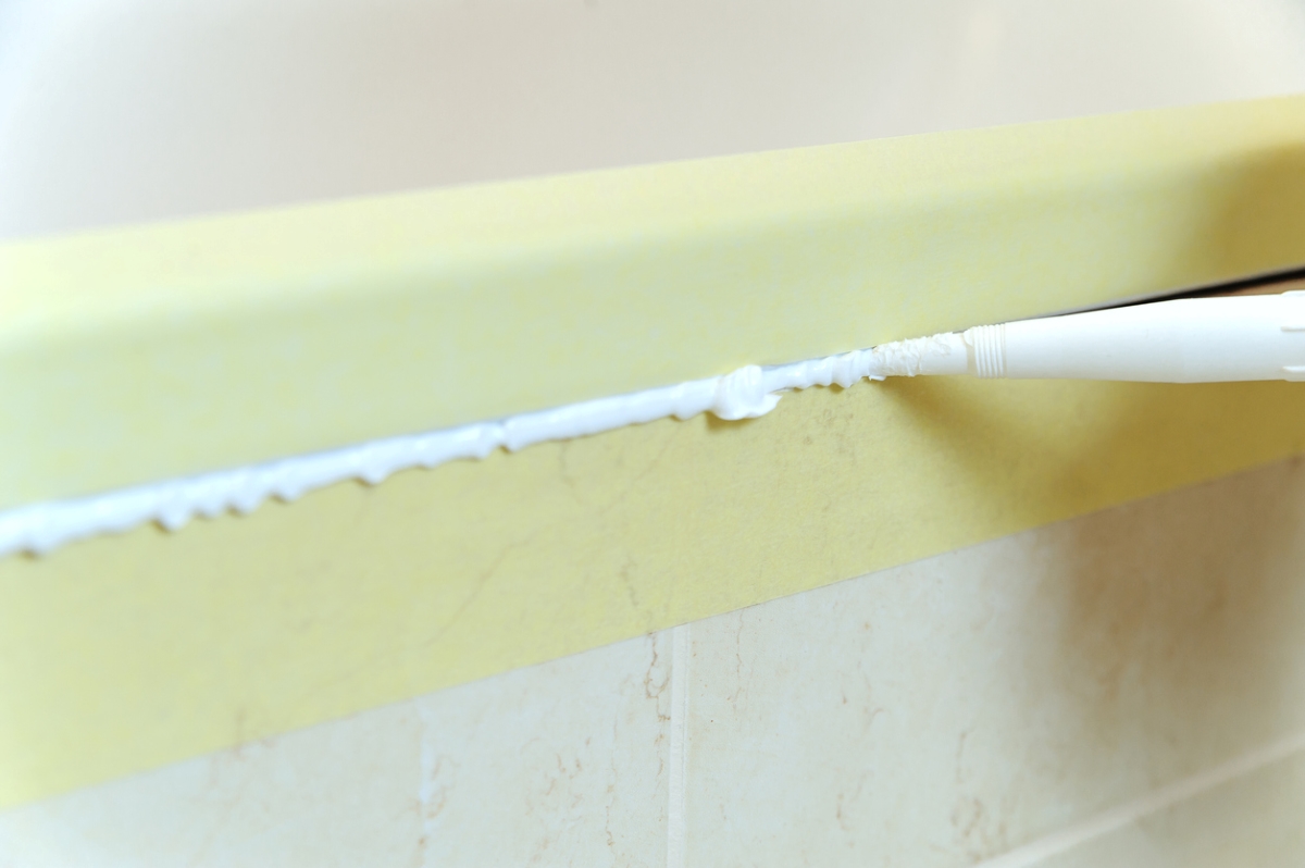 Uneven caulking along bathroom seal.