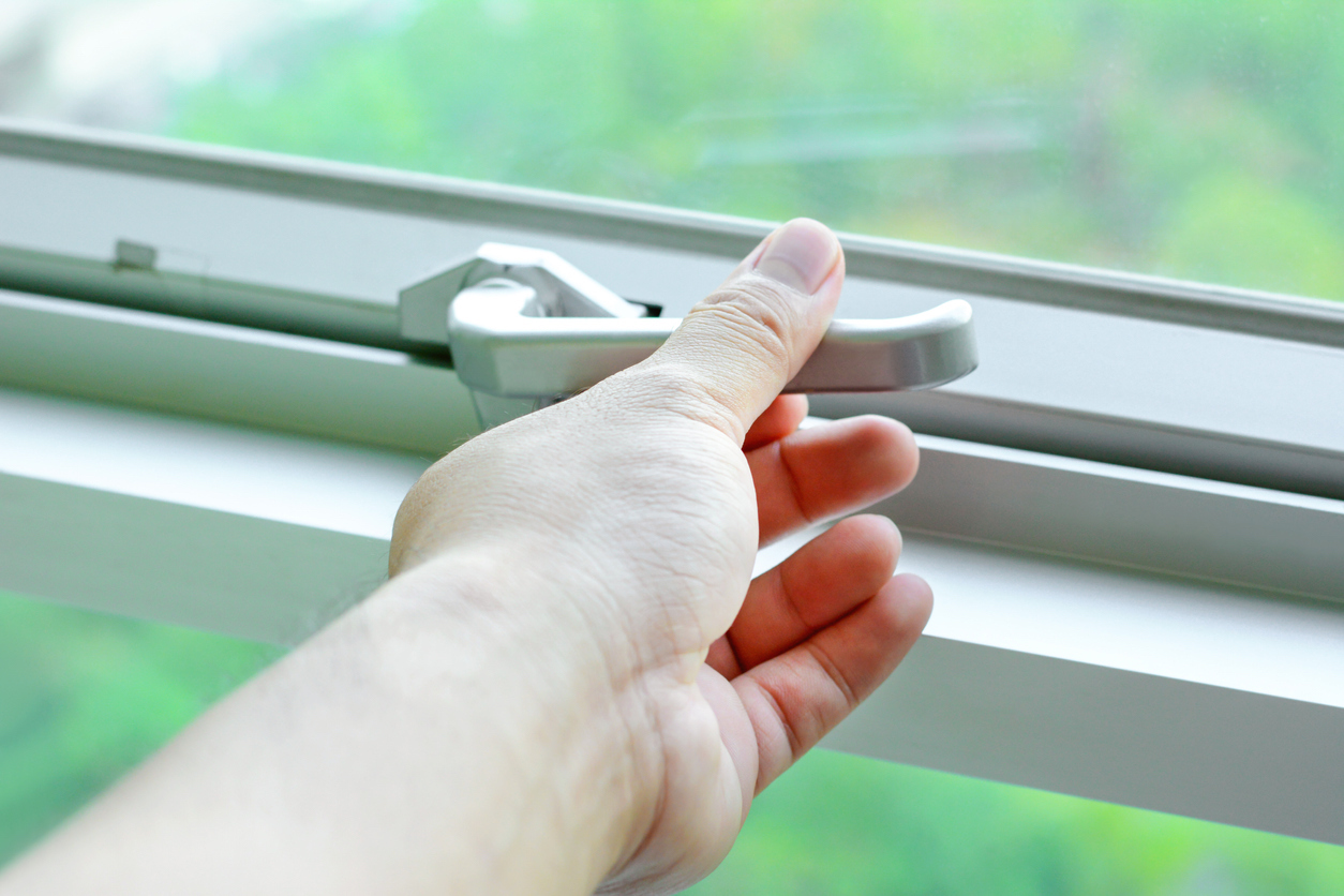 Woman securing the lock on a home's window.