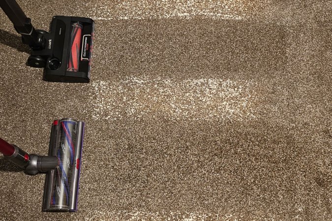 Dyson vs Shark vacuums in use cleaning carpeting during testing.