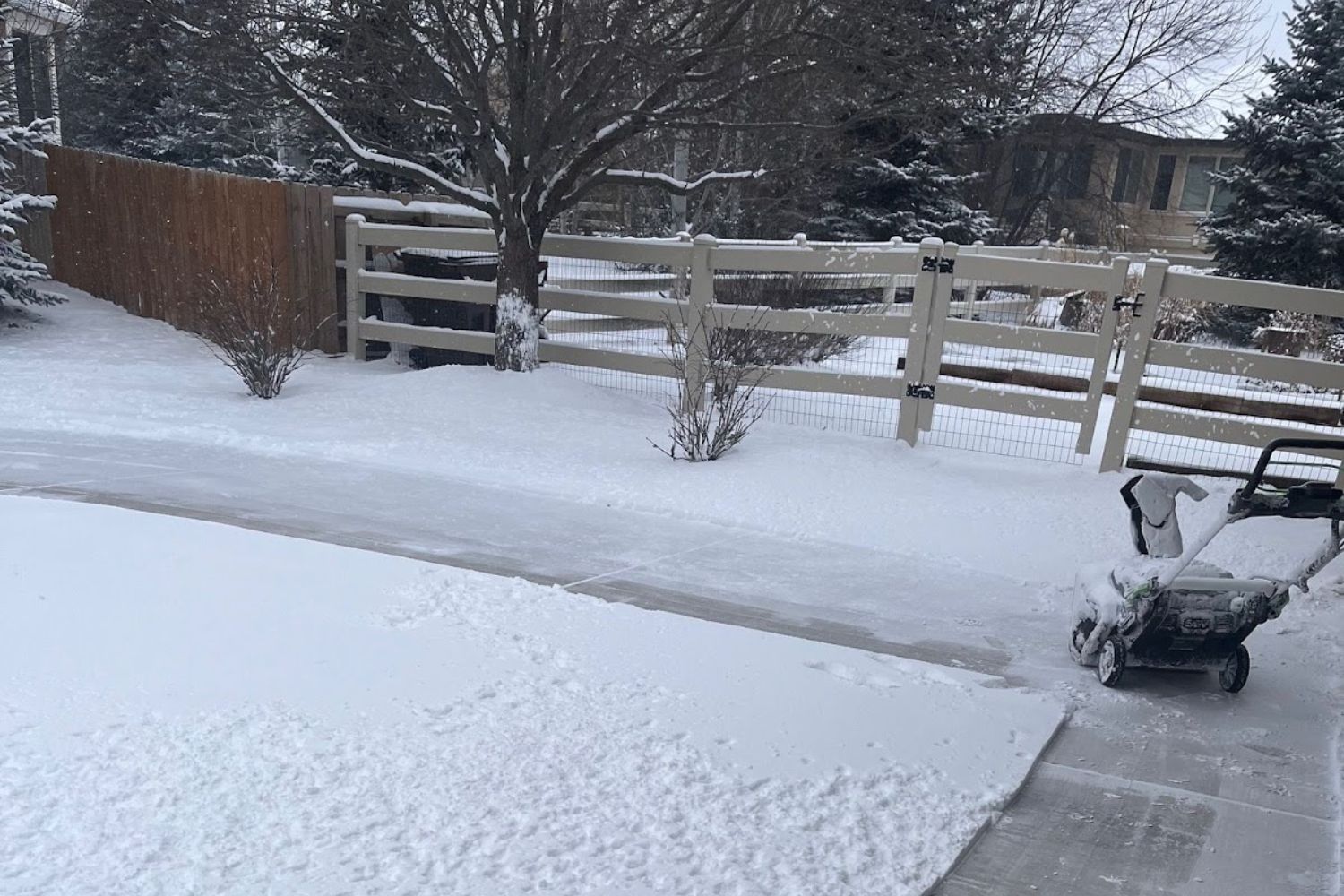 The Ego Lightweight Snow Blower parked at the end of cleared corner of snow.