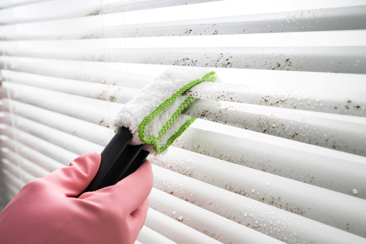 Using special blind cleaning tool to wipe dust off blinds.