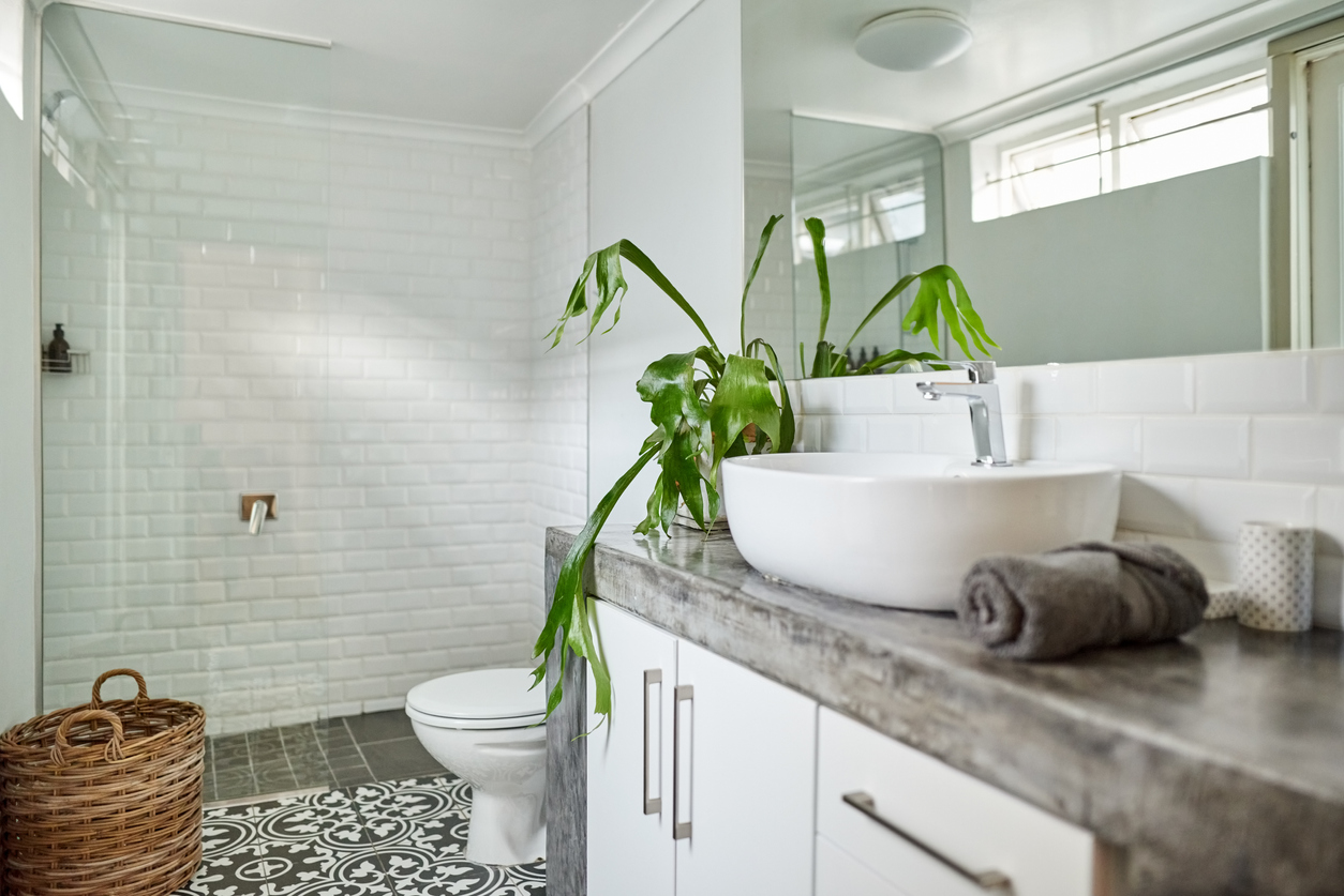 3/4 sized bathroom with grey countertops and shower with white tile.