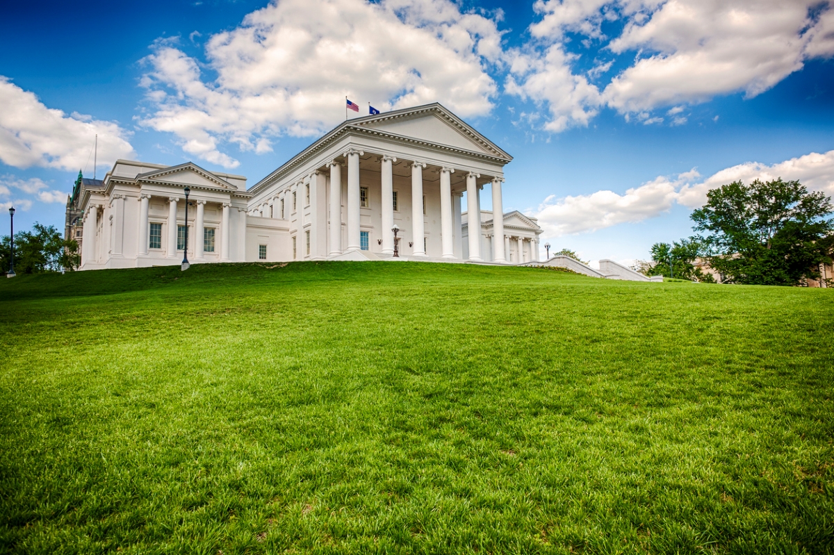 State capitol building on top of grassy hill.