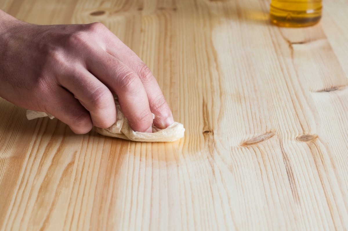 Hand oiling wood surface.