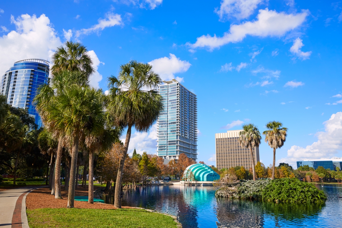 City skyline with palm trees and lake.