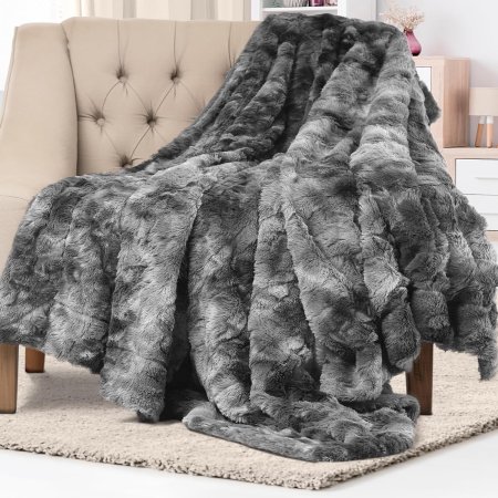  The Everlasting Comfort Luxury Faux Fur Throw Blanket draped over the arm of a chair.