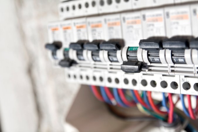 A row of circuit breakers and red and blue wires on the best circuit breaker.