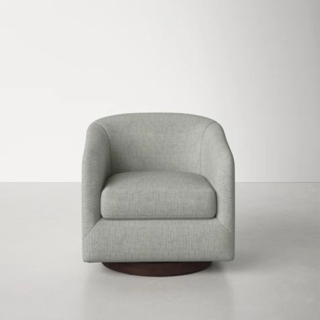  The AllModern Bennett Upholstered Swivel Barrel Chair on a grey floor in an empty room.