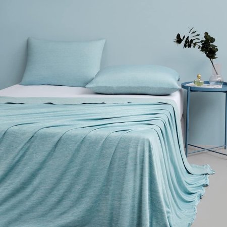  The Elegear Revolutionary Cooling Blanket draped diagonally across a bed.