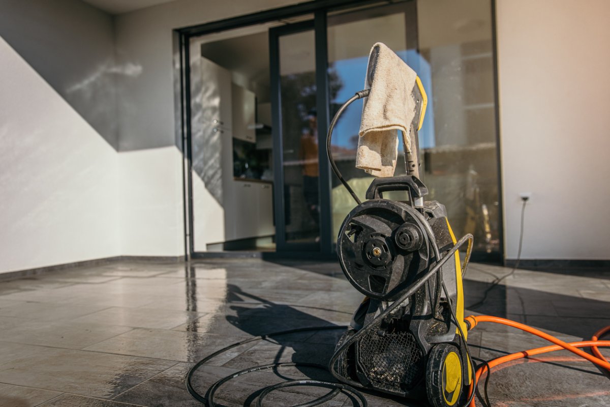 A close up of a pressure washer on a wet deck. 