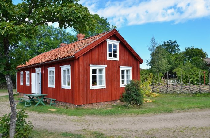 A view of a red barndominium on a clear day.