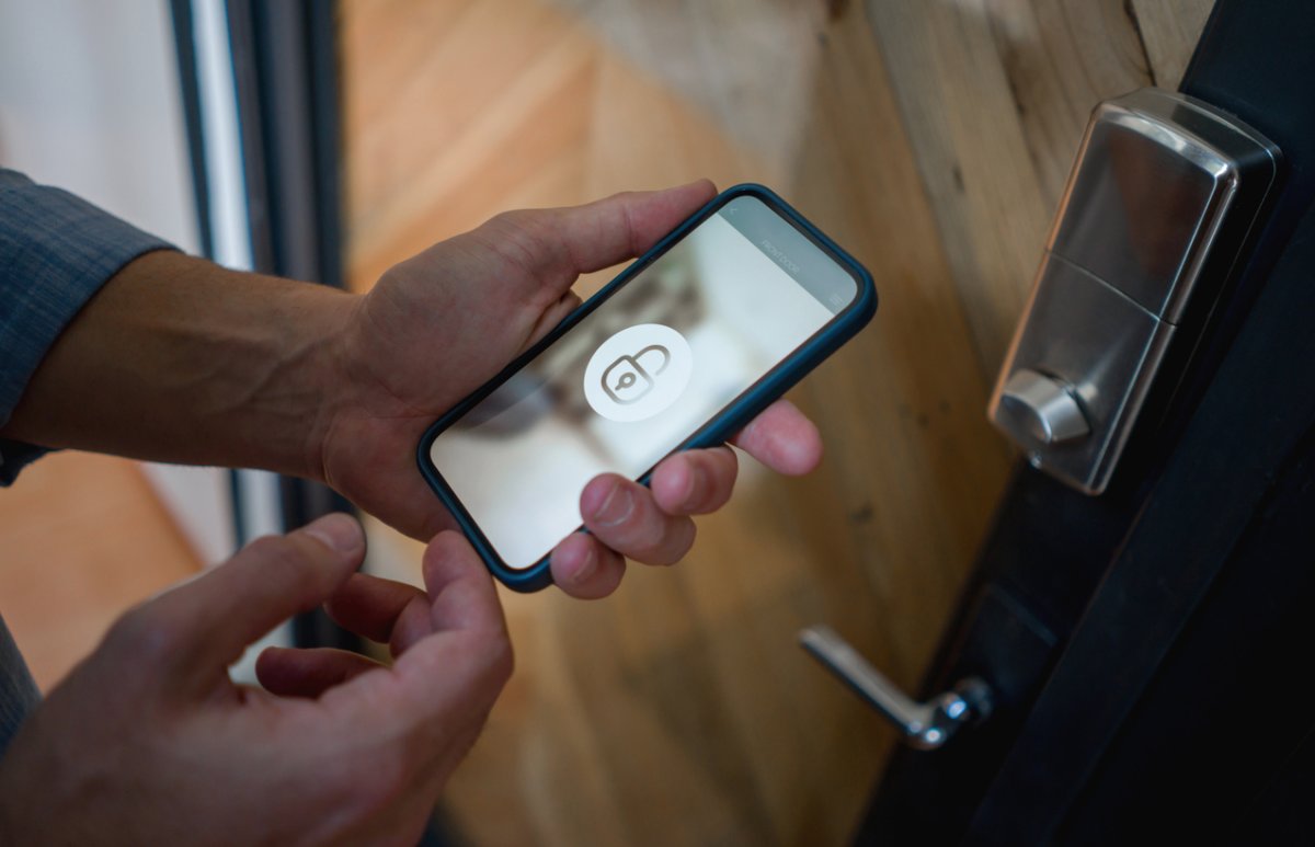 a close up of a hand holding a smart phone with a graphic of a lock on it.