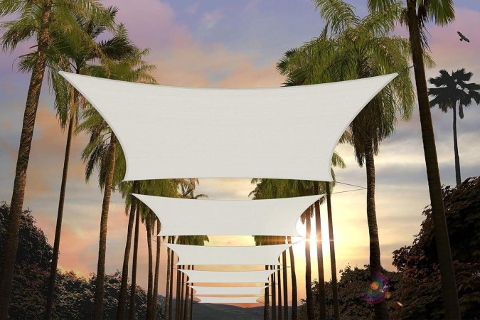  Several Amgo Rectangle Sun Shade Sails installed between palm trees.