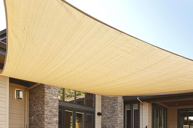  The Love Story Permeable Rectangle Sun Shade Sail installed next to a house.