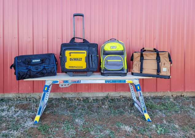 Several of the best tool bags on a workbench outdoors before testing.