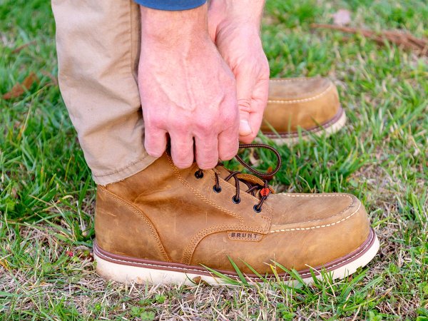 A person tying the laces on the best work boots during testing.