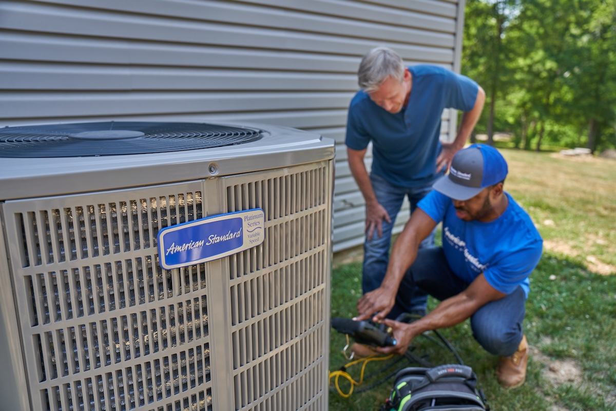 A homeowner with an American Standard HVAC professional asking and answering questions about air-source heat pumps <a href=