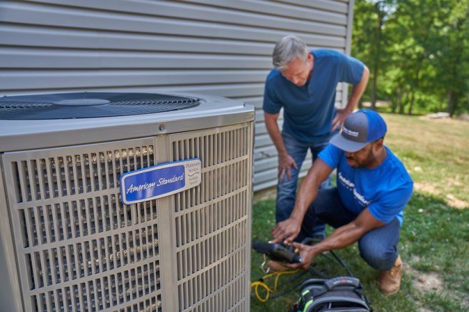 A homeowner with an American Standard HVAC professional asking and answering questions about air-source heat pumps and installing one.